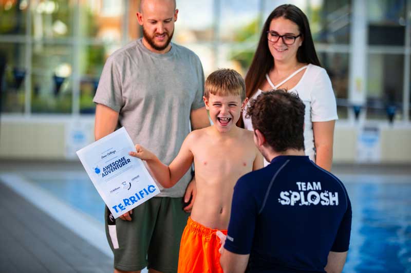 baby in swimming lesson with instructor and parent